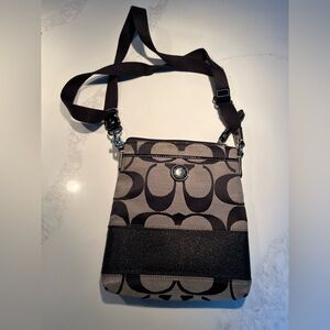 Tan & black canvas coach crossbody bag.  Two outside pockets.